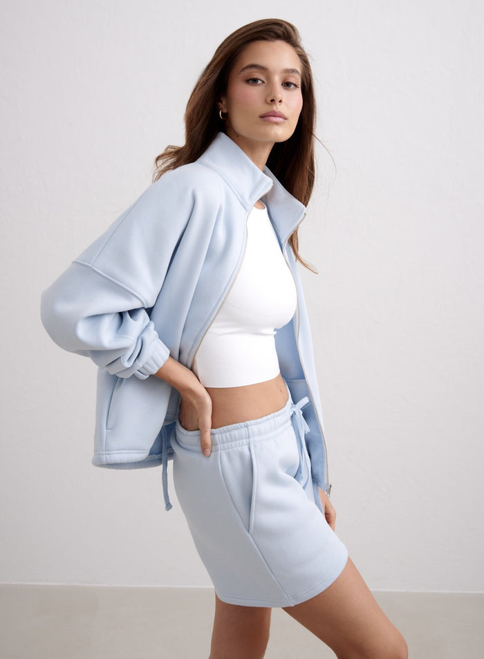 Vaaleansiniset Aura Script Sweat Shorts -shortsit, yhteensopiva college-takki ja valkoinen toppi. [S-174cm]