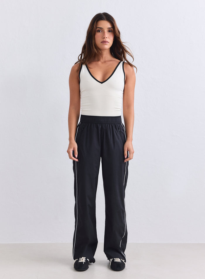 Mustat aim'n Balance Tracksuit Pants -verkkarit valkoisilla sivuraidoilla ja rennolla kudotulla designilla. [S-165cm]