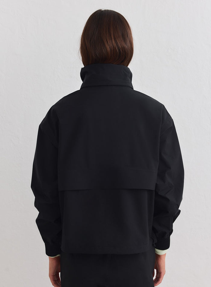Musta aim'n Waterproof Stretch Anorak takaapäin, korkea kaulus ja tuuletusaukko selässä. [xs-178cm]