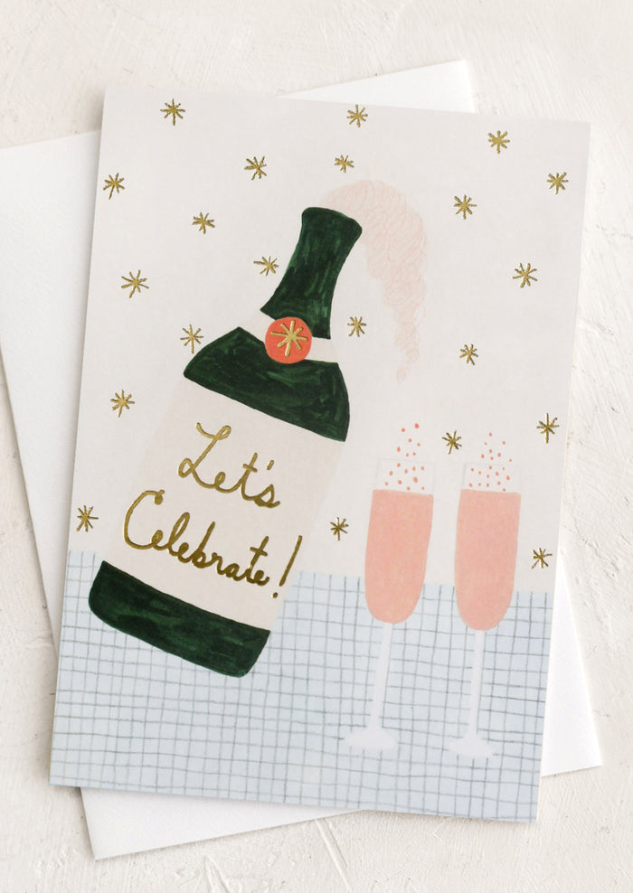 A card with illustration of a bottle of champagne and two flutes, text reads "Let's celebrate!".