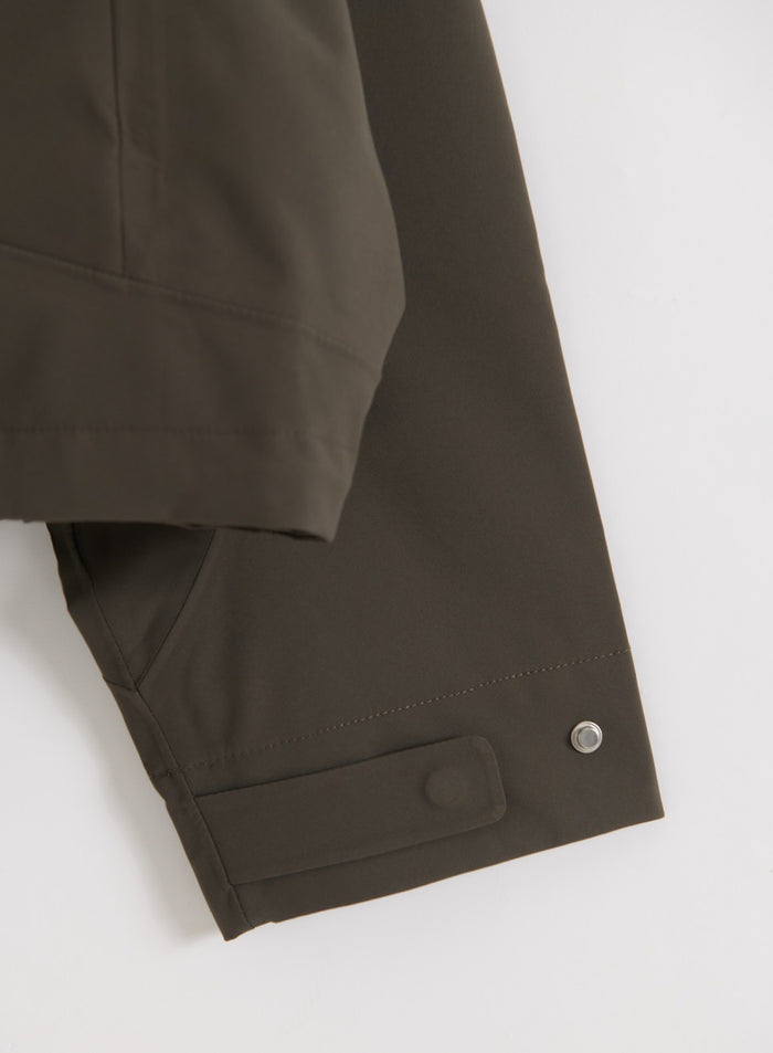 Dark Ivy Waterproof Jacket -takin hihan yksityiskohta, jossa näkyy nappikiinnitys