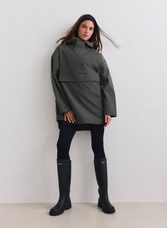 Vedenpitävä Dark Ivy -värinen ylisuuri anorakki, mustat leggingsit ja kumisaappaat merkiltä aim'n. [M-178cm]
