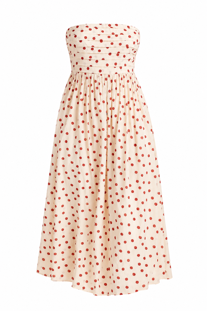 Women's cream strapless midi dress with red polka dots, a fitted bodice and a flowing skirt, styled with strappy heels.