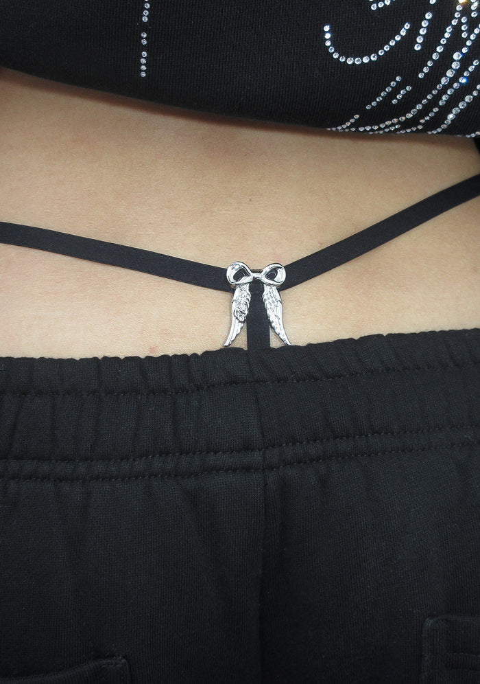 Close-up of the back view of a black g-string featuring an angel wing charm in the center.