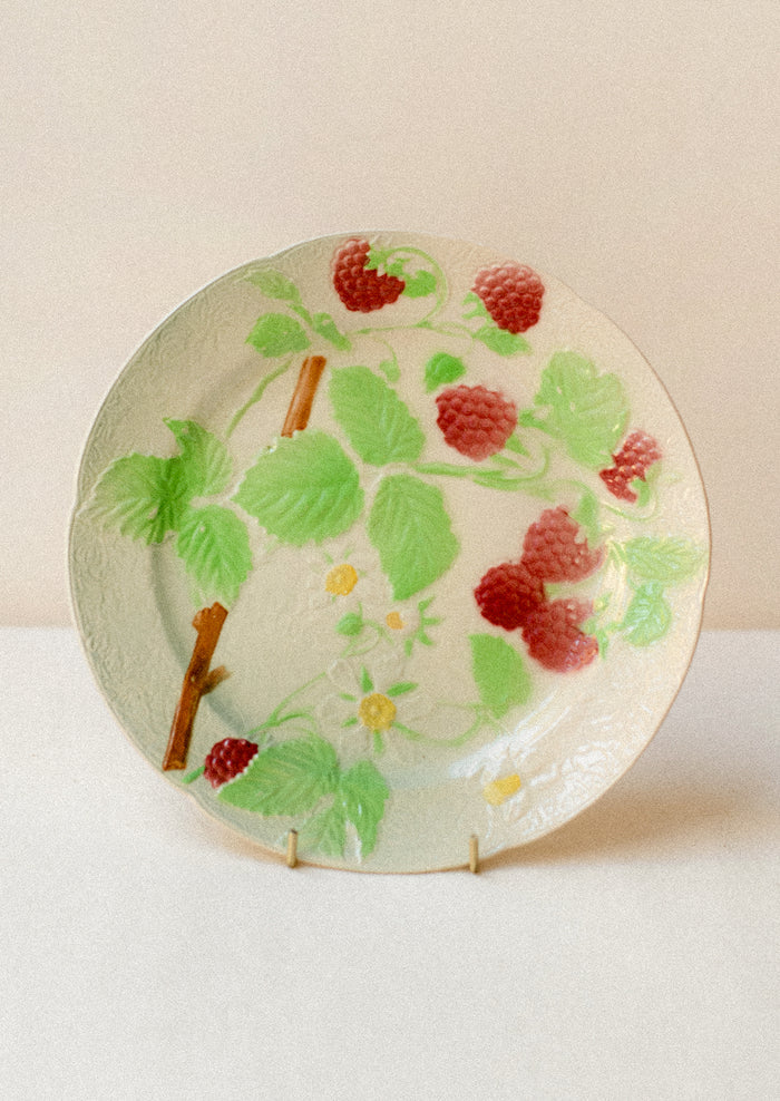 A ceramic plate in ivory with hand painted raspberry motif.