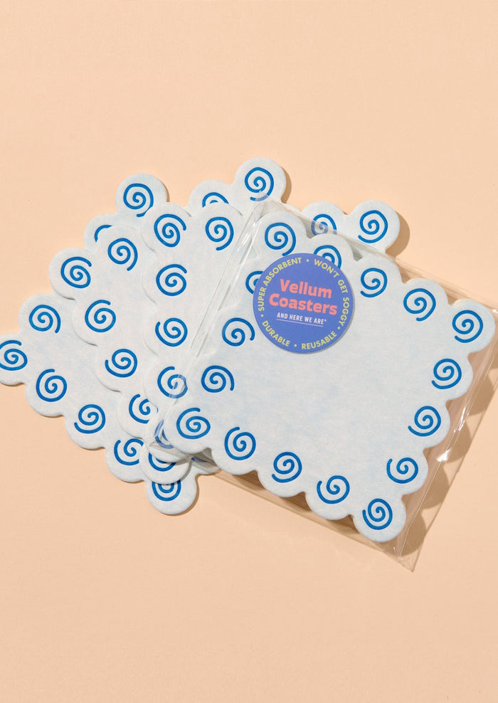 Set of blue coasters with blue spiral design on a beige background