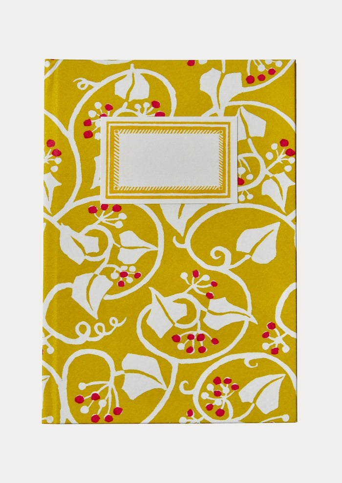 Decorative notebook with a yellow background and white floral pattern