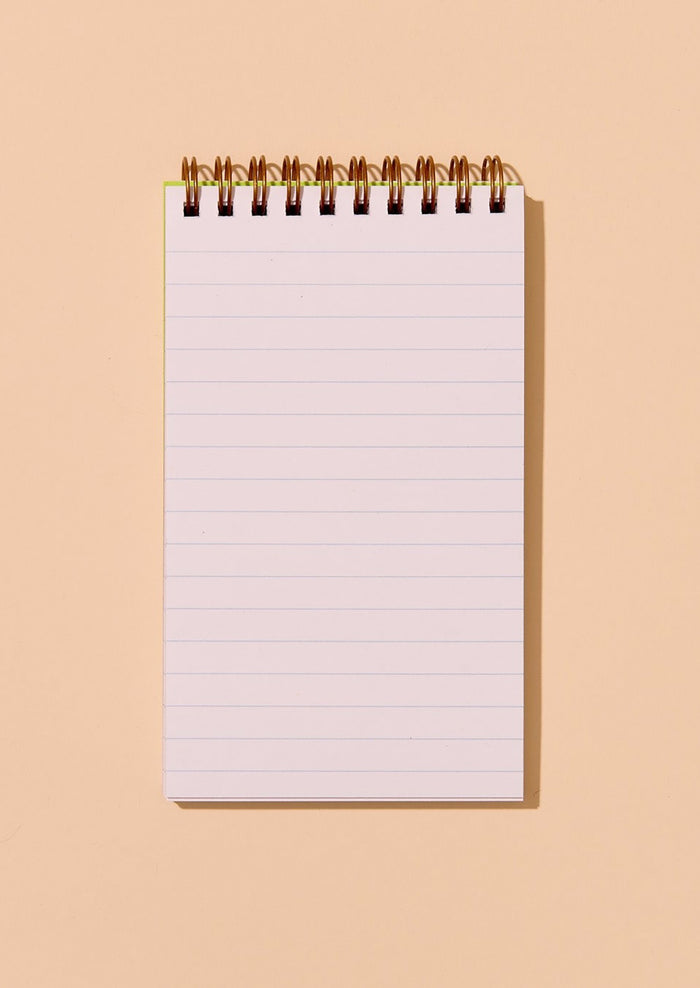 Ruled spiral-bound notebook on a beige background