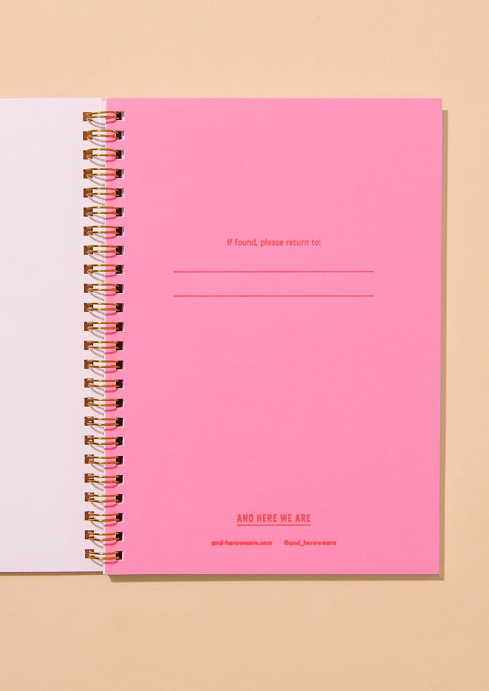 Pink notebook with text on a beige background